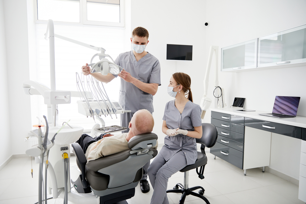Hospital,Two,Doctors,In,Medical,Uniform,Looking,Into,Sick,Pacient